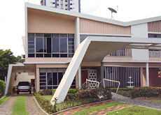 Fotografia mostra a Casa Bittencourt, um projeto de 1957 do arquiteto Camilo Porto de Oliveira. A casa de dois andares tem elementos característicos da arquitetura moderna, como os brise-soleil verticais na fachada e as colunas inclinadas.