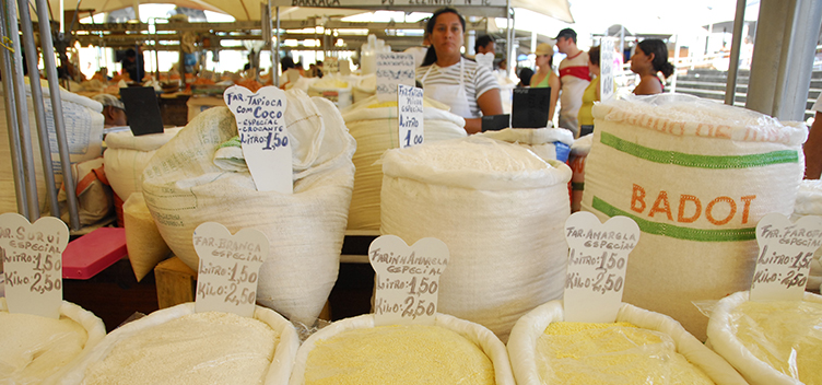 #ParaTodosLerem: Imagem mostra vários sacos de farinha expostos em uma feira e pessoas ao fundo